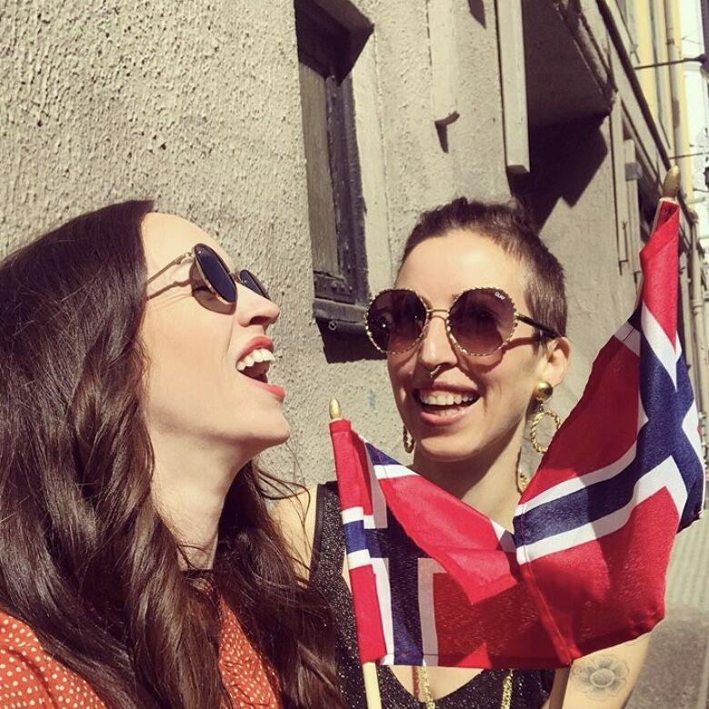 Synne og Monika vifter med 17.mai flagg. Solbriller fra Quay, vist på modell. Foto