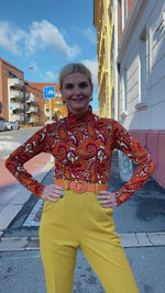 Last inn og spill av video i Gallerivisningen, Pologenser i paisleymønster fra Dianas Vintage. Orange, burgunder, hvit og sennepsgul. Lange ermer og høy hals.
