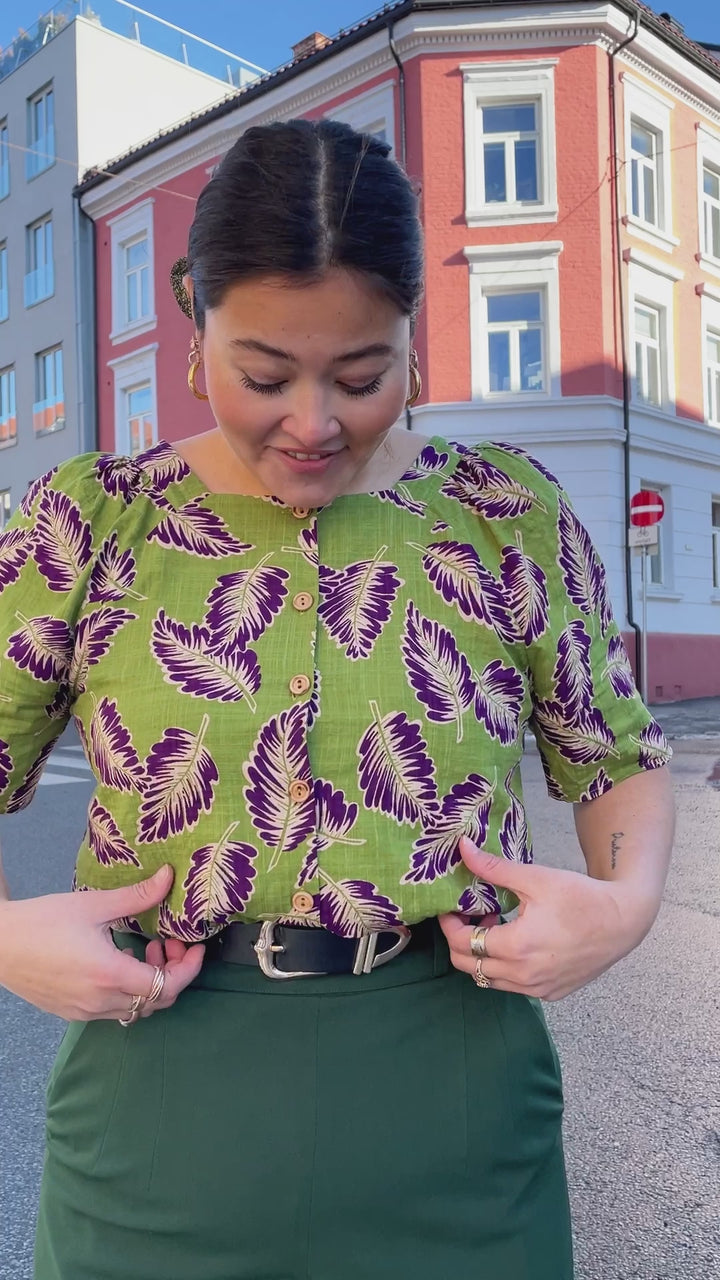 Eplegrønn bluse med lilla og hvite blader fra King Louie. Firkantet hals, vide ermer og knapper i front