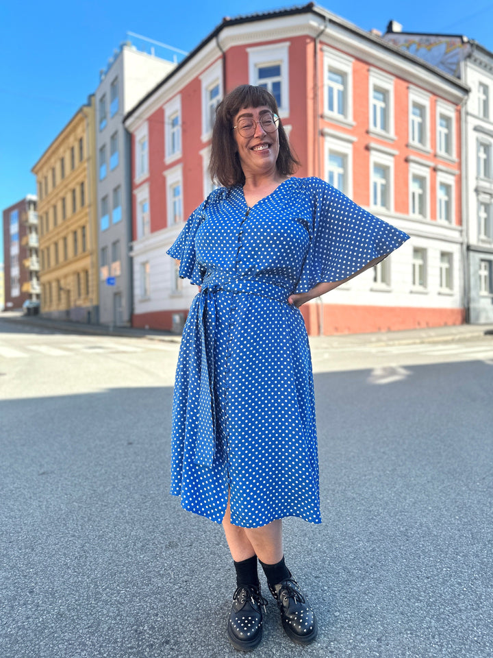 Dianas Vintage kjole. Kort blå kjole med hvite prikker, klokkeermer og midjebelte.