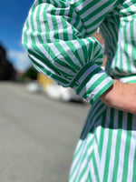 Last inn bildet i Galleri-visningsprogrammet, Stripete grønn og hvit skjorte/bluse med stor krage fra Dianas Vintage. Knapper hele veien ned og lange ballongermer med mansjetter.
