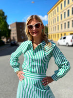 Last inn bildet i Galleri-visningsprogrammet, Stripete grønn og hvit skjorte/bluse med stor krage fra Dianas Vintage. Knapper hele veien ned og lange ballongermer med mansjetter.
